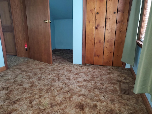 unfurnished bedroom featuring visible vents, carpet flooring, and a closet