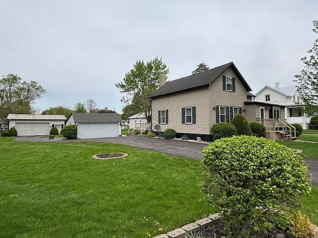 view of side of home with an outbuilding, a yard, a chimney, and a detached garage