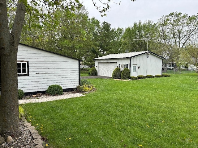 view of yard featuring a detached garage and fence