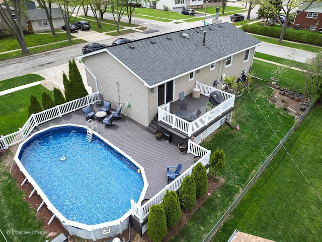exterior space featuring fence, a deck, an outdoor hangout area, a fenced in pool, and a lawn