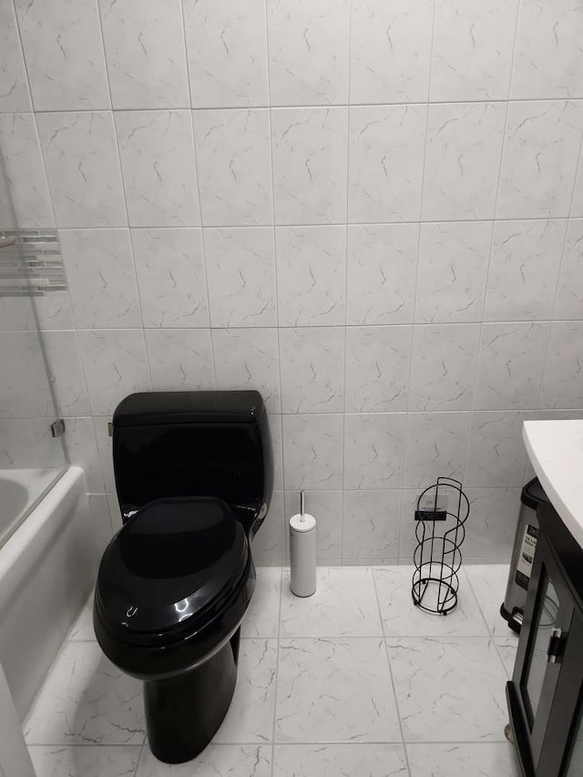 bathroom with vanity, washtub / shower combination, toilet, and marble finish floor