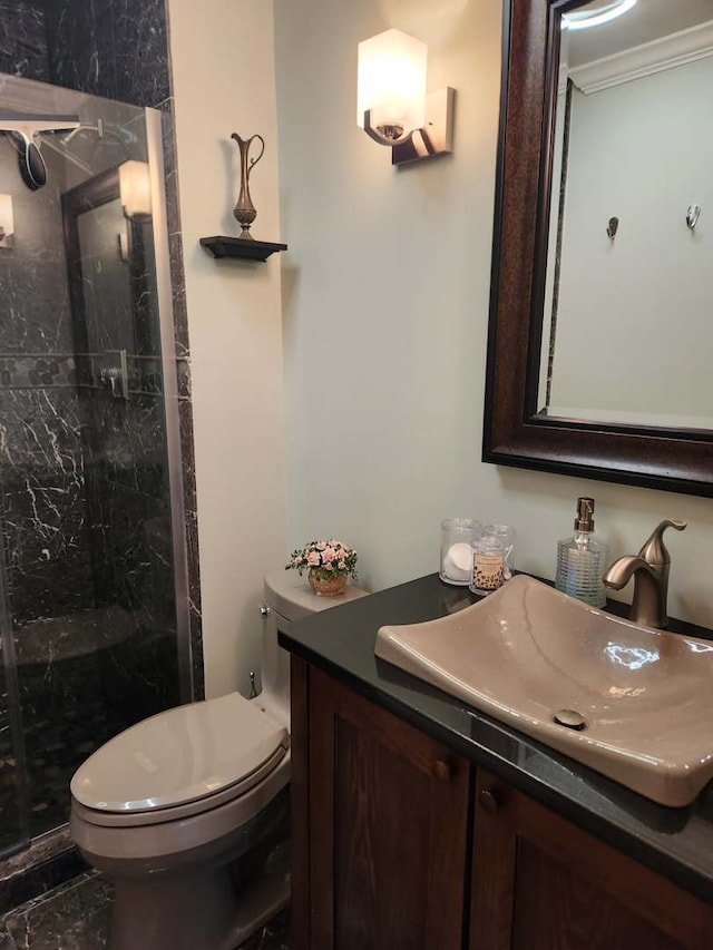 full bath featuring vanity, ornamental molding, toilet, and a shower stall