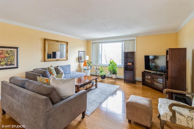 living area with a textured ceiling, ornamental molding, baseboard heating, and light wood-style floors