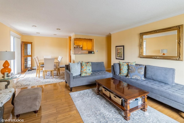living area with crown molding and light wood-style flooring