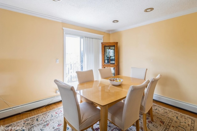 dining space featuring a baseboard radiator, a textured ceiling, ornamental molding, and wood finished floors