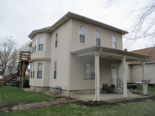 view of side of home with a yard and stairway