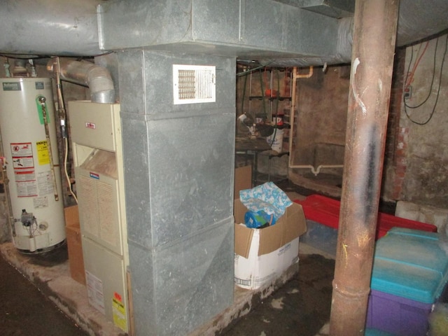 utility room featuring visible vents, heating unit, and water heater