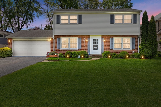2011 Brentwood Rd, Northbrook, IL 60062 - colonial house with driveway, brick siding, an attached garage, and a front lawn