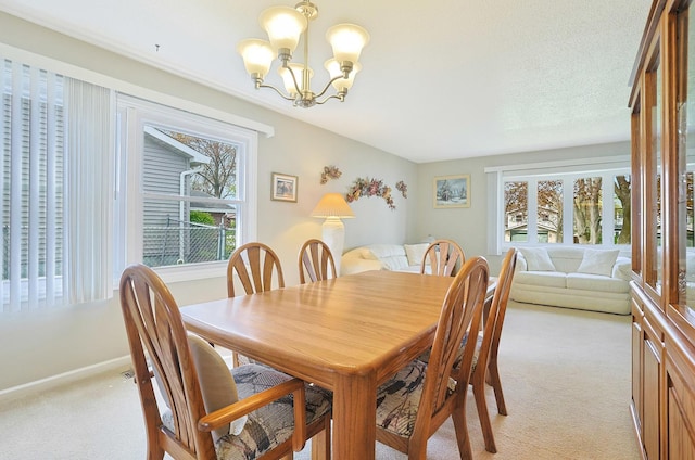 dining space with baseboards, an inviting chandelier, and light carpet