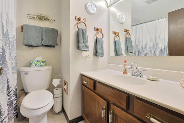 bathroom with vanity, tile patterned flooring, baseboards, and toilet