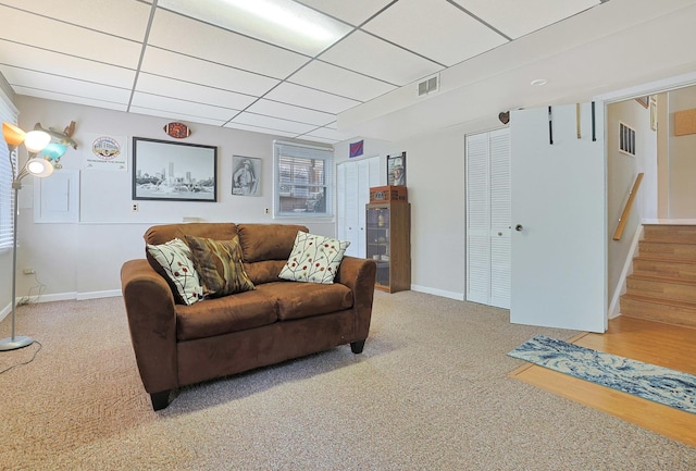 living room featuring stairway, baseboards, carpet flooring, and visible vents