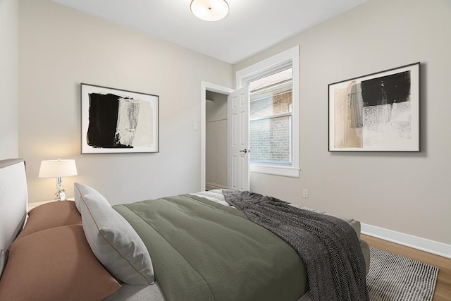 bedroom with baseboards and wood finished floors