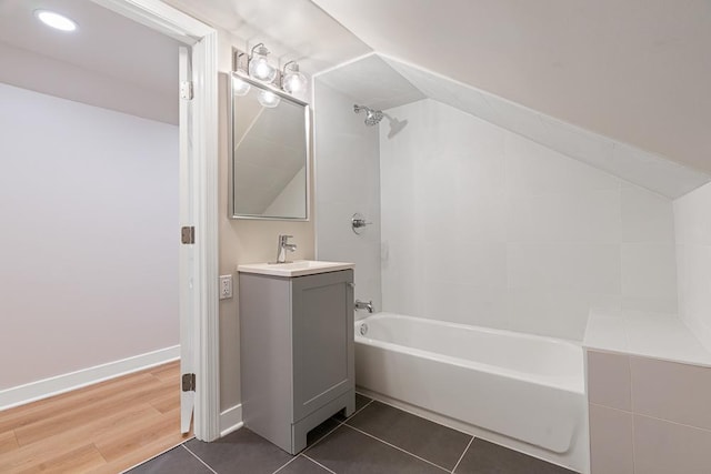 full bathroom with tub / shower combination, tile patterned floors, vaulted ceiling, and vanity