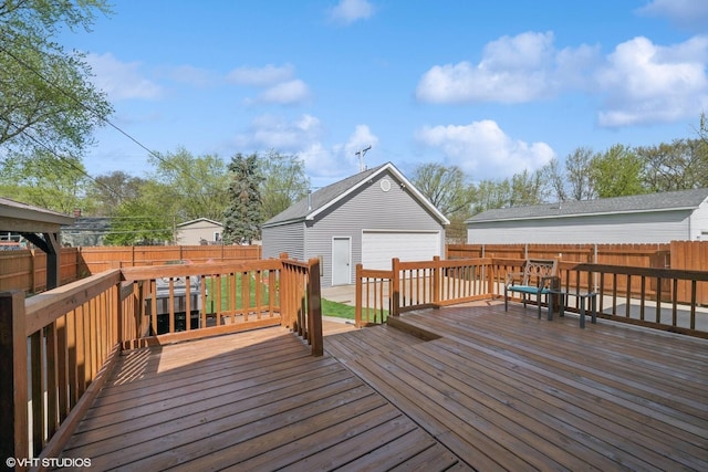 wooden terrace featuring a fenced backyard, an outdoor structure, and a garage