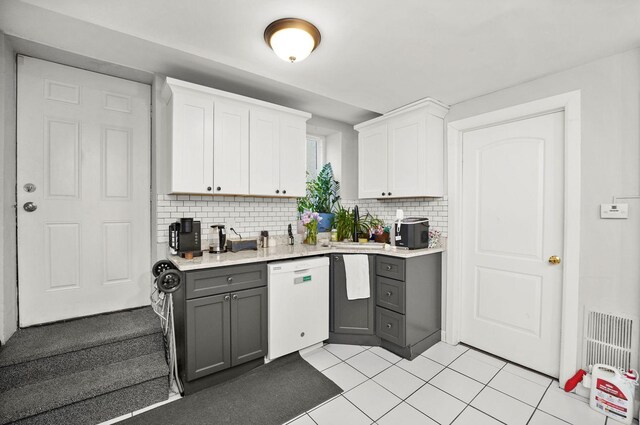 kitchen featuring white cabinetry, tasteful backsplash, light countertops, white dishwasher, and gray cabinets