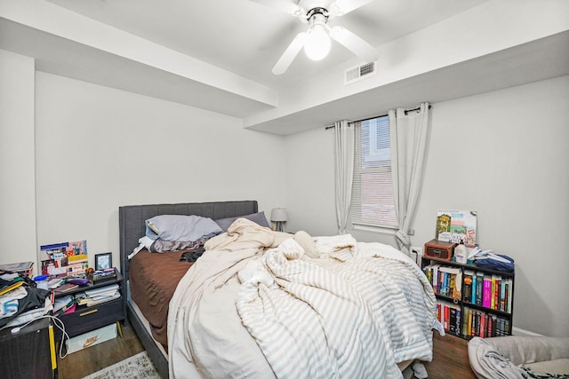 bedroom with visible vents, wood finished floors, and ceiling fan