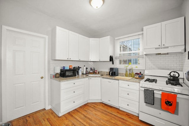 kitchen with tasteful backsplash, white appliances, light wood finished floors, and under cabinet range hood