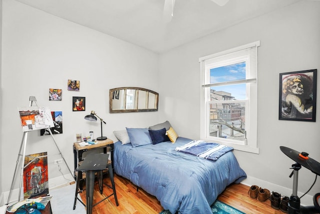 bedroom featuring wood finished floors, ceiling fan, and baseboards