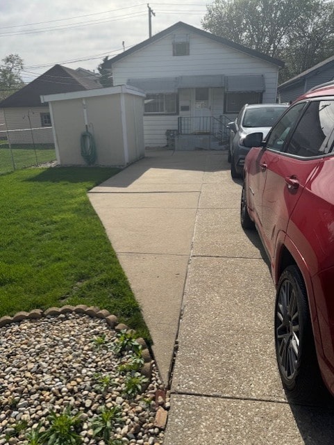 exterior space featuring a front lawn, fence, and concrete driveway