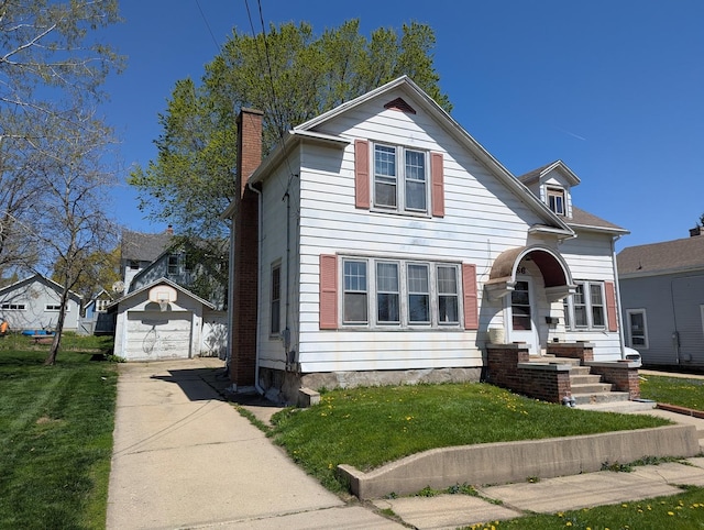 view of front of home with a chimney, an outdoor structure, a garage, a front lawn, and concrete driveway