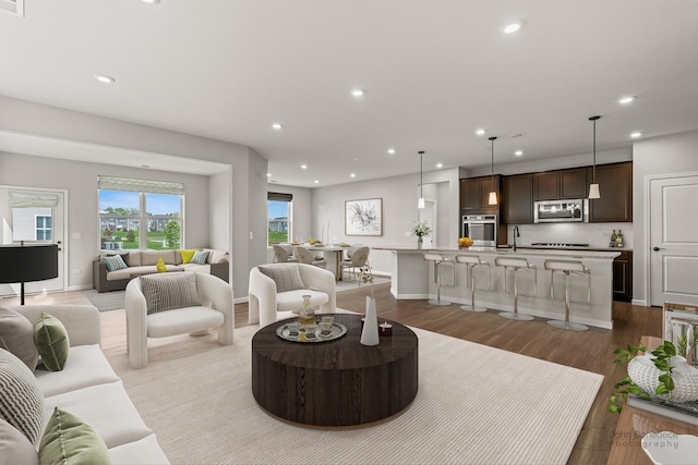 living area featuring baseboards, recessed lighting, and wood finished floors