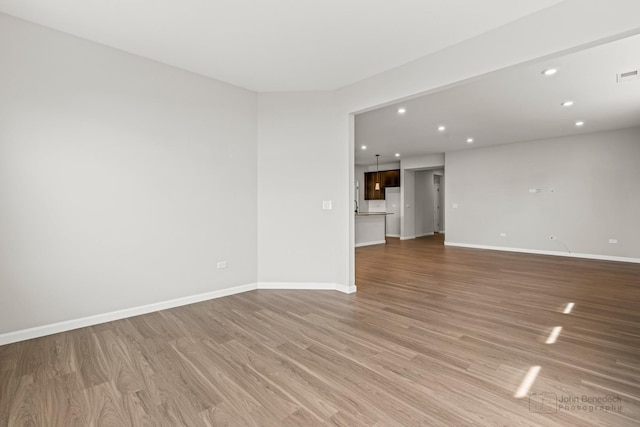 unfurnished room with baseboards, recessed lighting, light wood finished floors, and visible vents