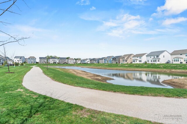 view of property's community with a residential view, a water view, and a yard