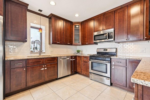 kitchen with light tile patterned floors, stainless steel appliances, tasteful backsplash, and a sink