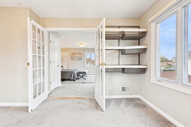 interior space with visible vents, carpet flooring, french doors, and baseboards
