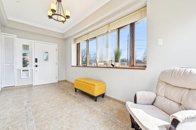 foyer entrance featuring a chandelier, crown molding, and plenty of natural light