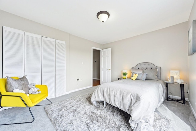 carpeted bedroom featuring a closet and baseboards