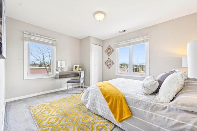 carpeted bedroom featuring a closet, visible vents, and baseboards