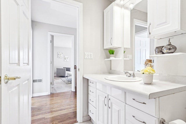 interior space with visible vents, wood finished floors, vanity, and baseboards