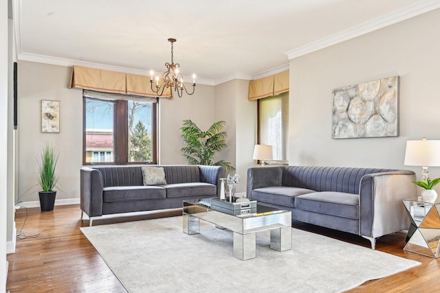 living room with crown molding, a chandelier, wood finished floors, and baseboards