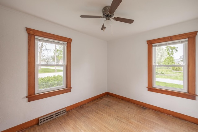 unfurnished room with baseboards, visible vents, ceiling fan, and light wood-style floors