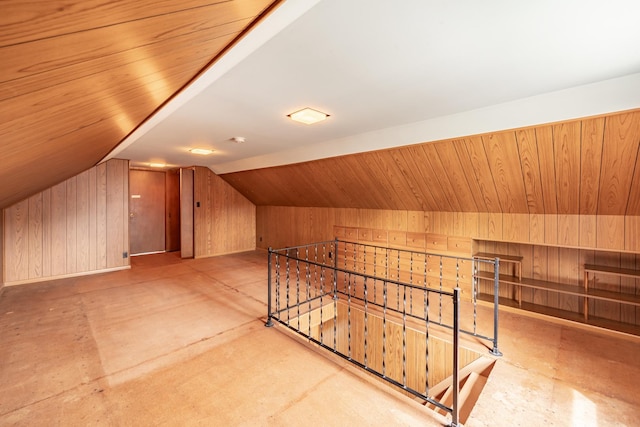 additional living space with wood walls and lofted ceiling