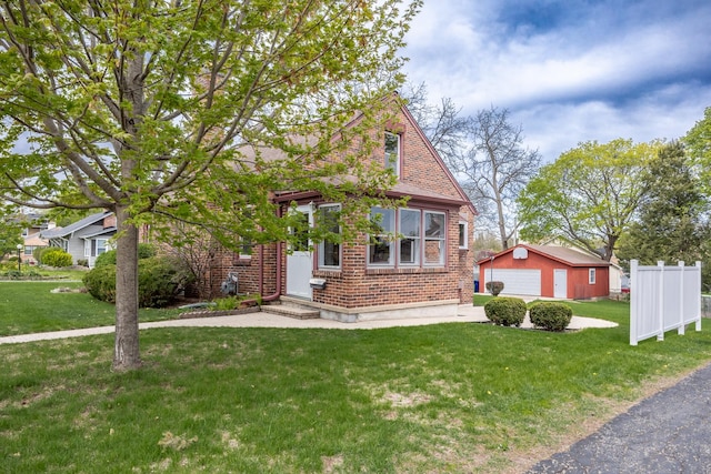 view of front of house featuring a detached garage, brick siding, an outdoor structure, and a front lawn