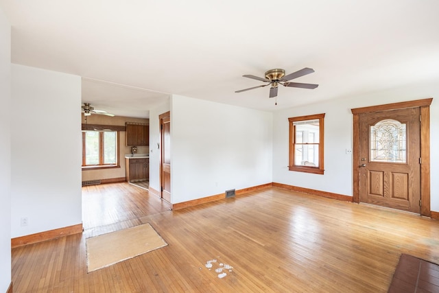 entryway with baseboards, ceiling fan, and light wood-type flooring
