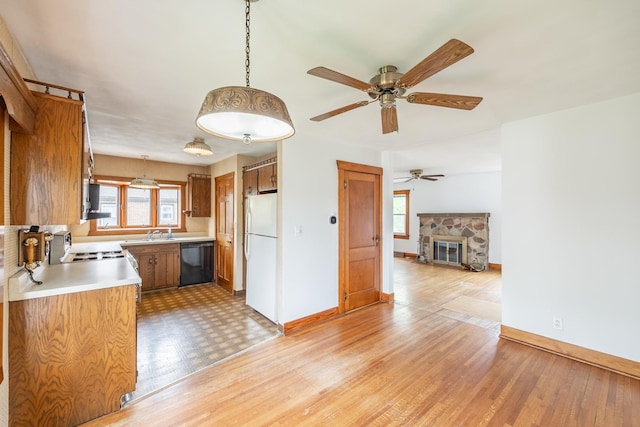 kitchen featuring freestanding refrigerator, dishwasher, a wealth of natural light, and light countertops