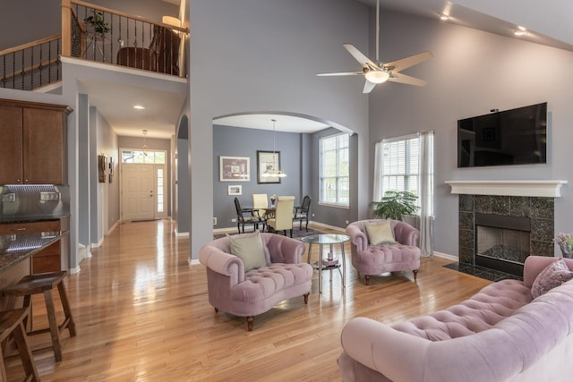 825 Canton Dr, Oswego, IL 60543 - living area with arched walkways, light wood-style flooring, a towering ceiling, and ceiling fan