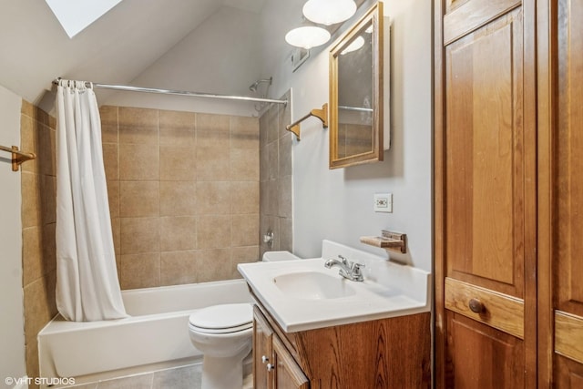 bathroom featuring vanity, tile patterned floors, toilet, lofted ceiling with skylight, and shower / bath combo with shower curtain