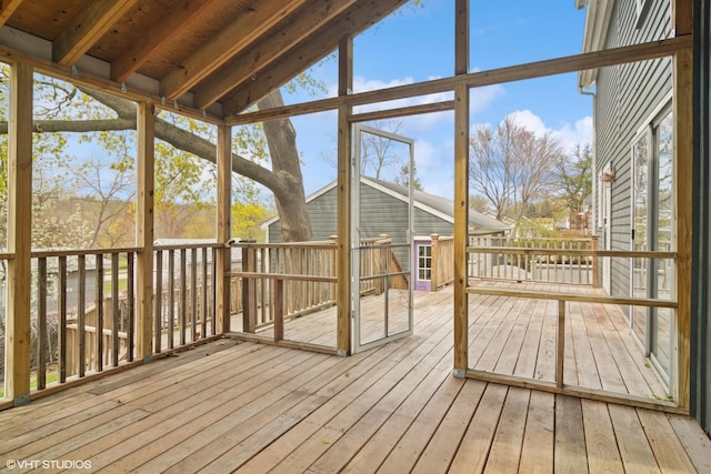 unfurnished sunroom with beam ceiling