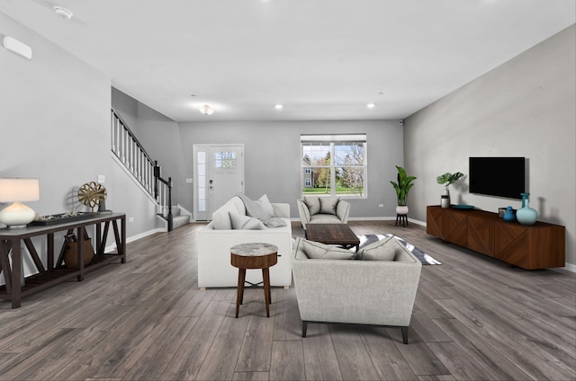 living area featuring baseboards, stairs, and wood finished floors