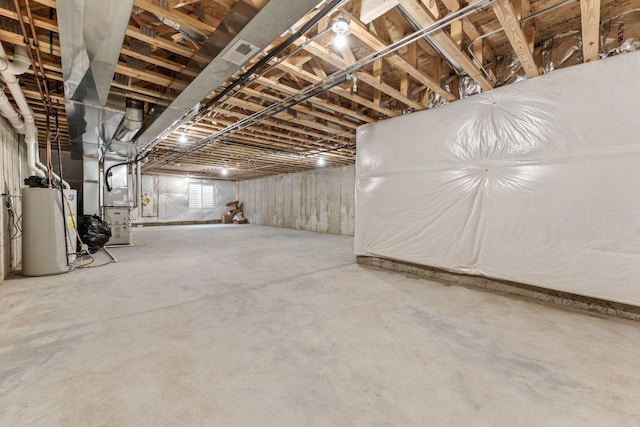 below grade area featuring heating unit, visible vents, and gas water heater