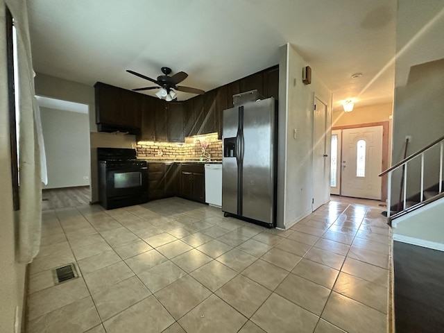5326 Yale Ln, Matteson, IL 60443 - kitchen with black gas stove, stainless steel fridge, light tile patterned flooring, backsplash, and range hood