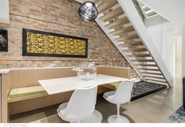 1833 W Evergreen Ave, Chicago, IL 60622 - dining area with stairs, brick wall, and a wainscoted wall