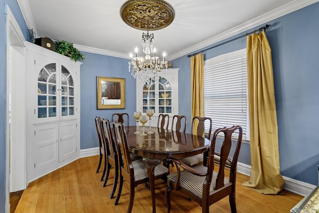dining area featuring a chandelier, baseboards, ornamental molding, and light wood finished floors