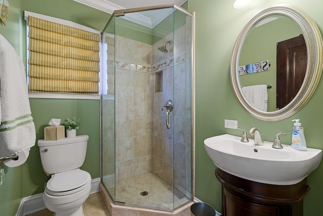 bathroom with crown molding, a sink, a stall shower, toilet, and tile patterned flooring