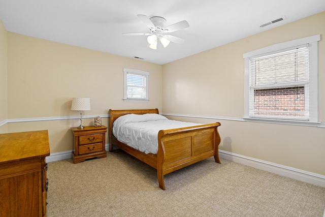 bedroom with visible vents, light carpet, and baseboards