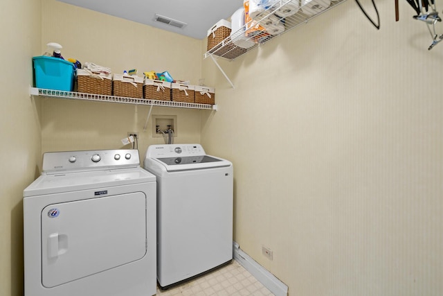 clothes washing area featuring visible vents, washer and dryer, light floors, and laundry area
